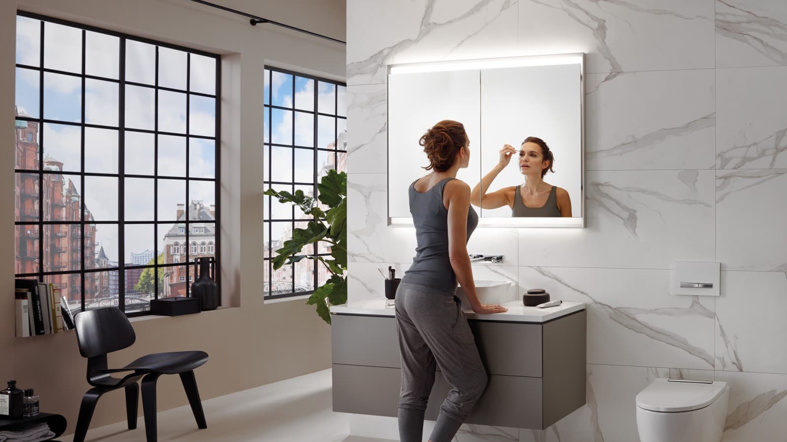 O femeie într-o baie dotată cu Geberit ComfortLight O femeie într-o baie dotată cu Geberit ComfortLight
