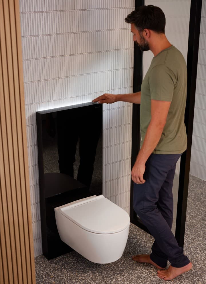 Bărbat lângă Geberit Monolith Plus cu ComfortLight Bărbat lângă Geberit Monolith Plus cu ComfortLight